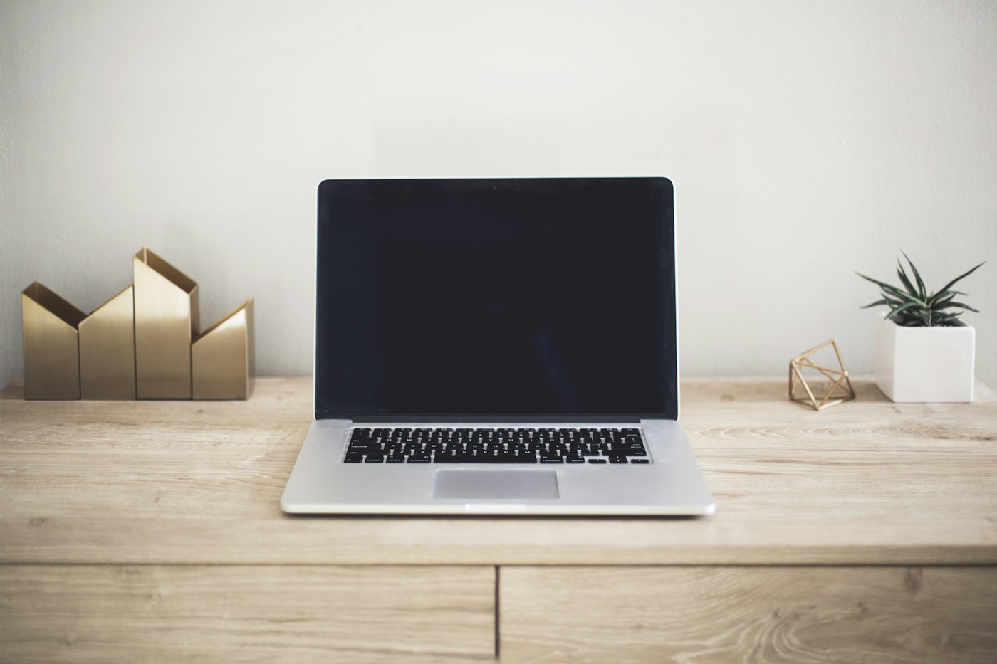 棕色桌子上的 MacBook Pro。说明性照片;不是对指定产品或组织的描述。